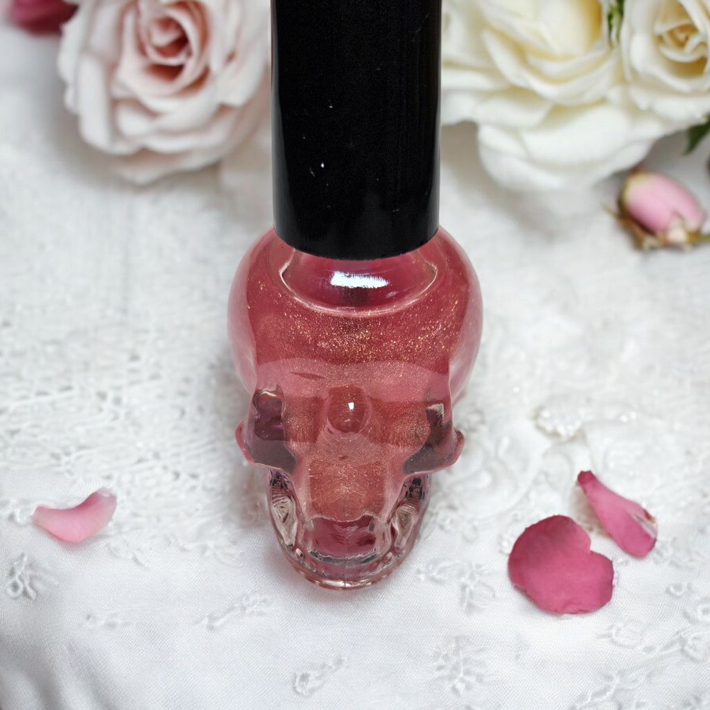 Botella con forma de calavera con aceite para cutículas con aroma a rosa.